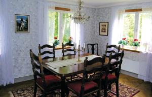 uma sala de jantar com uma mesa de madeira e cadeiras em Lovely Home In Ambjrnarp With Wifi em Emtashult