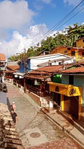 a person walking down a street next to buildings at Cantinho da Luna in Morro de São Paulo