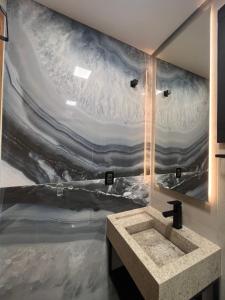 a bathroom with a wave mural on the wall at Casa da Pedra Ibitipoca in Lima Duarte