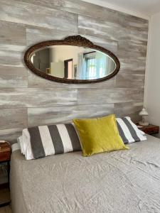 1 dormitorio con 1 cama con espejo en la pared en Viento Azul Guest House, en Punta del Este
