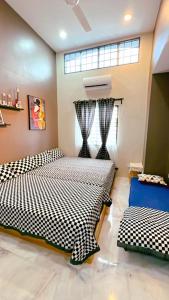 a bedroom with two beds with black and white sheets at Bonjour Homestay in Sungai Pelik