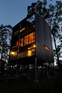 a large building with glass windows at night at Gold Coast Tree Houses in Neranwood