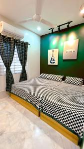 a bedroom with a bed and a green wall at Bonjour Homestay in Sungai Pelik