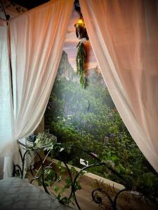 un dormitorio con una cortina y una pintura de un bosque en INSOLITE - Le Gîte de l'Anneau - Immersion GARANTIE - VERDUN Centre - Géré par Presta-Zen'Services en Verdún