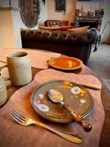 une table avec deux assiettes et une fourchette et une cuillère dans l'établissement NEWS * Le Gîte de l’Anneau* Insolite, à Verdun-sur-Meuse