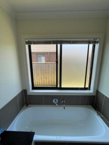 庫克角的住宿－Point Cook Private Room，带浴缸的浴室和窗户