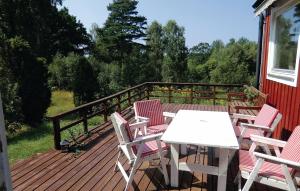 a wooden deck with a table and chairs on it at Beautiful Home In Ljungbyhed With Sauna in Röstånga