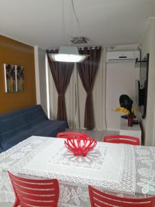 mesa de comedor con sillas rojas y sofá azul en NA BEIRA MAR DE PAJUCARA- EDIF NEO- APARTAMENTO QUARTO E SALA - POSSUI VARANDA- VISTA LATERAL DO MAR-RUA JULIO PLECH FILHO 60 ESQUINA COM AVENIDA DOUTOR ANTONIO GOUVEIA - CONSUMO ELETRICO É PAGO No CKECK-OUT - 1 KWH É 1,35 REIAS - TEM TELA DE PROTEÇÃO, en Maceió