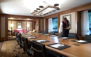 Un homme debout dans une salle de conférence avec une longue table dans l'établissement Divan Istanbul, à Istanbul