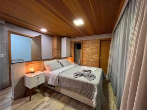 a bedroom with a large bed and a mirror at Casa da Pedra Ibitipoca in Lima Duarte
