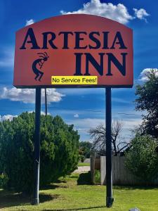 a sign for an australia inn on two poles at Artesia Inn- No Service Fees in Artesia