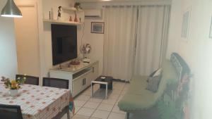 sala de estar con mesa y TV en NA BEIRA MAR DE PAJUCARA- EDIF NEO- APARTAMENTO QUARTO E SALA- TEM VARANDA - VISTA LATERAL DO MAR- RUA JULIO PLECH FILHO 60 ESQUINA COM AVENIDA DOUTOR ANTONIO GOUVEIA - CONSUMO ELETRICO É PAGO No CKECK-OUT 1KWH É 1,35 REIAS, en Maceió