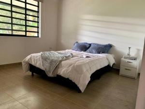 a bedroom with a large bed with blue pillows at Lee TODO lo que incluye para Familia (Guateque) in Guateque