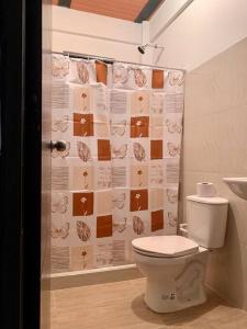 a bathroom with a toilet and a shower curtain at Lee TODO lo que incluye para Familia (Guateque) in Guateque