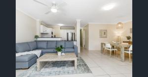 a living room with a blue couch and a table at Pacific Place Apartments in Gold Coast