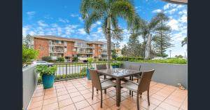 a patio with a table and chairs on a balcony at Pacific Place Apartments in Gold Coast