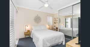 a bedroom with a white bed and a mirror at Pacific Place Apartments in Gold Coast +104 photos