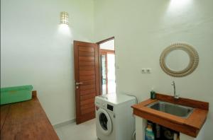 a bathroom with a washing machine and a sink at Villa Serenity in Candidasa