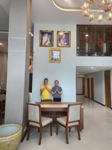 two men standing around a table in a room at August Residence in Bangkok