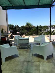 un patio con sillas blancas y un cochecito de bebé en Monoambiente, a 8 cuadras del centro a 13 decostanera en Corrientes