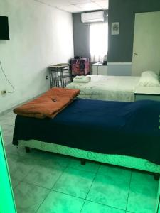 Dos camas en una habitación con una manta azul. en Monoambiente, a 8 cuadras del centro a 13 decostanera en Corrientes