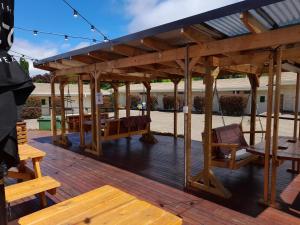 a wooden deck with a pergola and wooden benches at Redhill Cooma Motor Inn in Cooma