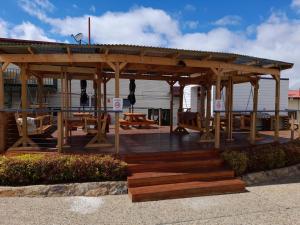 a wooden gazebo with wooden benches and tables at Redhill Cooma Motor Inn in Cooma