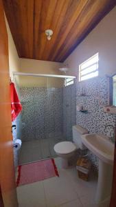 a bathroom with a toilet and a sink at Chalés Flor de Manacá in Alto Paraíso de Goiás