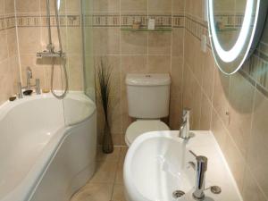 ein Badezimmer mit einer Badewanne, einem Waschbecken und einem WC in der Unterkunft The Pierhouse Hotel in Port Appin