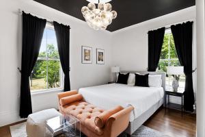 a bedroom with a bed and a chair and a chandelier at The Coach House in Salem