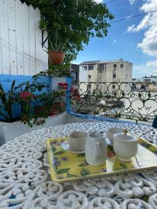 una mesa con una bandeja con tazones y tazas. en fabulous rooftop 2 colonial room for 4, en Santo Domingo