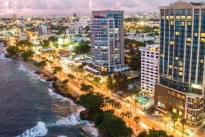 a city with tall buildings and the ocean at night at Colonial apartment for up to 4 person in Santo Domingo