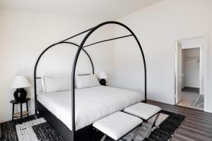 an iron canopy bed with white pillows in a bedroom at Friends and Family! Desert Oasis 3 Mi to Joshua Tree in Yucca Valley