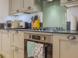 a kitchen with a stove and a microwave at Pippin Cottage in Bures Saint Mary