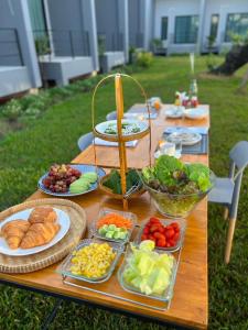 a wooden table with plates of food on it at Destino Hotel Surin 