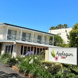 una señal para la posada del apopodio frente a un edificio en Applegum Inn en Toowoomba