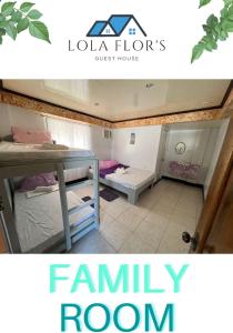 a room with two bunk beds and a family room at Lola Flor's Guest House in El Nido