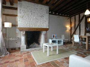 sala de estar con chimenea, mesa y sillas en Appart'Tourisme Blois Châteaux de la Loire, en Blois