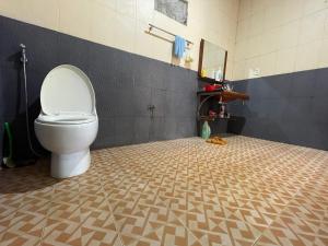a bathroom with a toilet and a tiled floor at family garden 