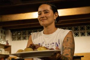 una mujer está sosteniendo un plato de comida en Hotel Bahía Aguacate en Capurganá