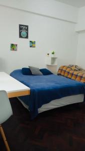 1 dormitorio con 2 camas y manta azul en Apartamento Av Corrientes Porteño en Buenos Aires