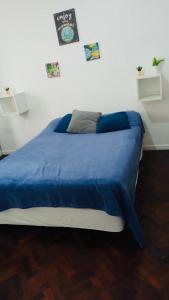 Una cama en una habitación con una manta azul. en Apartamento Av Corrientes Porteño en Buenos Aires
