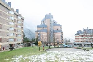 um grande edifício numa cidade com neve no chão em Apartamento Baqueira pie pistas cota 1500 em Baqueira-Beret