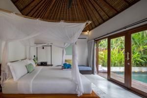 a bedroom with a white bed and a pool at Villa Markisa Echo Beach in Canggu