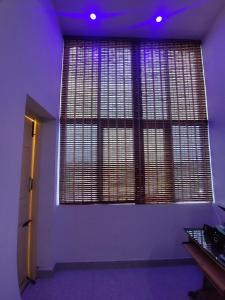 Zimmer mit einem großen Fenster mit violetten Lichtern in der Unterkunft Hotel Padma Shree , Madurai - Near Airport in Madurai