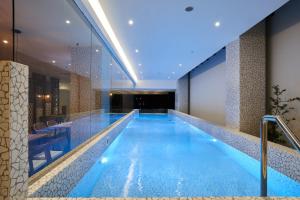 a large swimming pool in a hotel lobby at Cordela Suites Tasikmalaya in Tasikmalaya