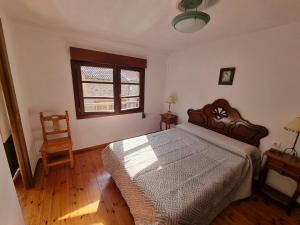Un dormitorio con una cama grande y una ventana en La Jomeruca ,espaciosa casa rural cerca de playa y montaña, en Carranceja