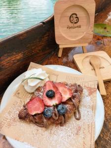 a plate of food with fruit on top on a table at Baan Thamachart in Watthana Nakhon