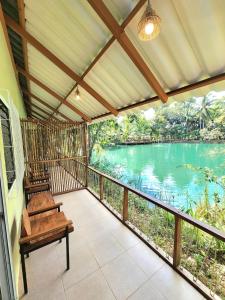 a screened in porch with a view of a river at Baan Thamachart in Watthana Nakhon