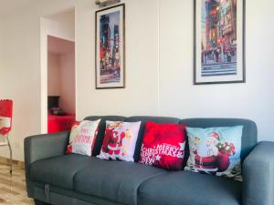 un divano blu con cuscini natalizi sopra in soggiorno di Cosmopolita Rojo a La Serena
